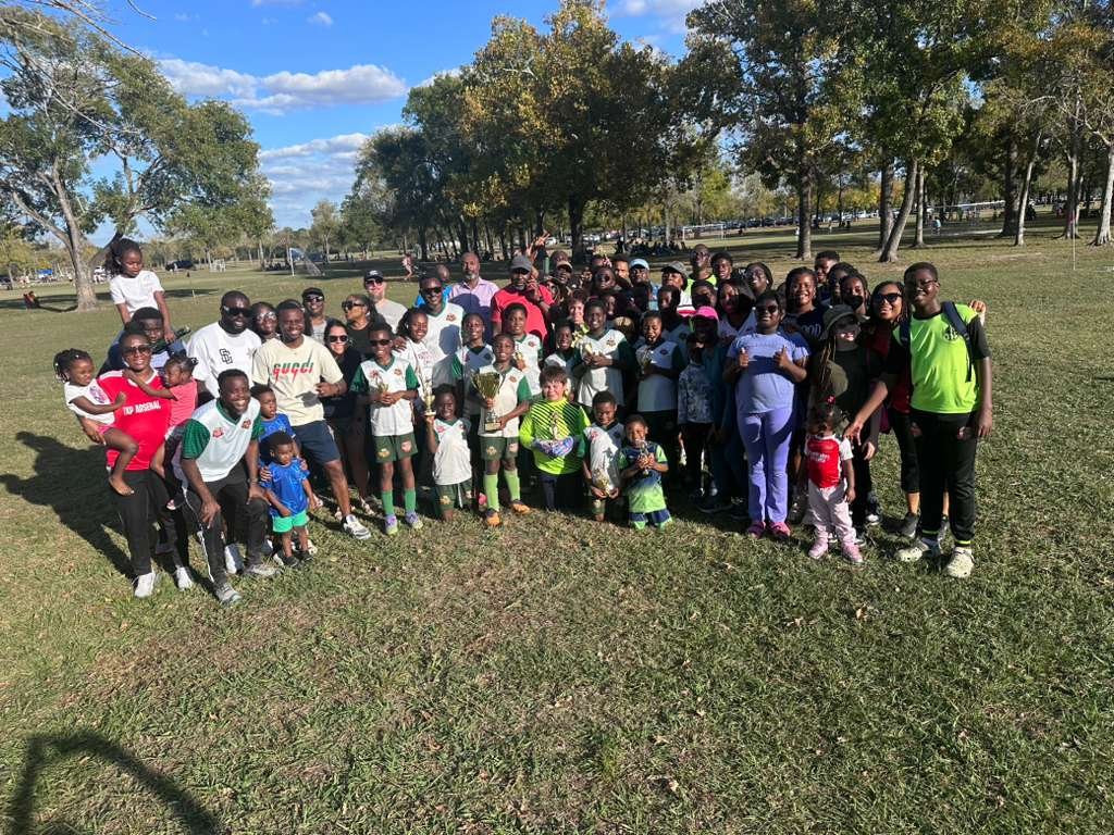 Redeemer Sports players, parents, and coaches gathered together for a group photo at the park